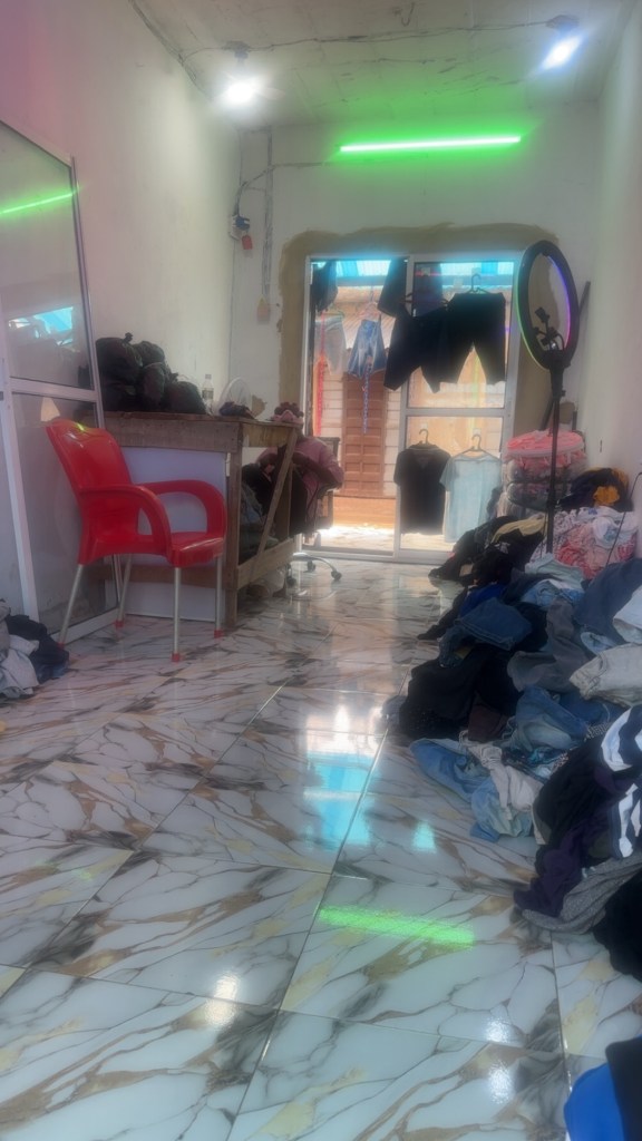 I Thrift Shop that has chair and clothes on the floor 