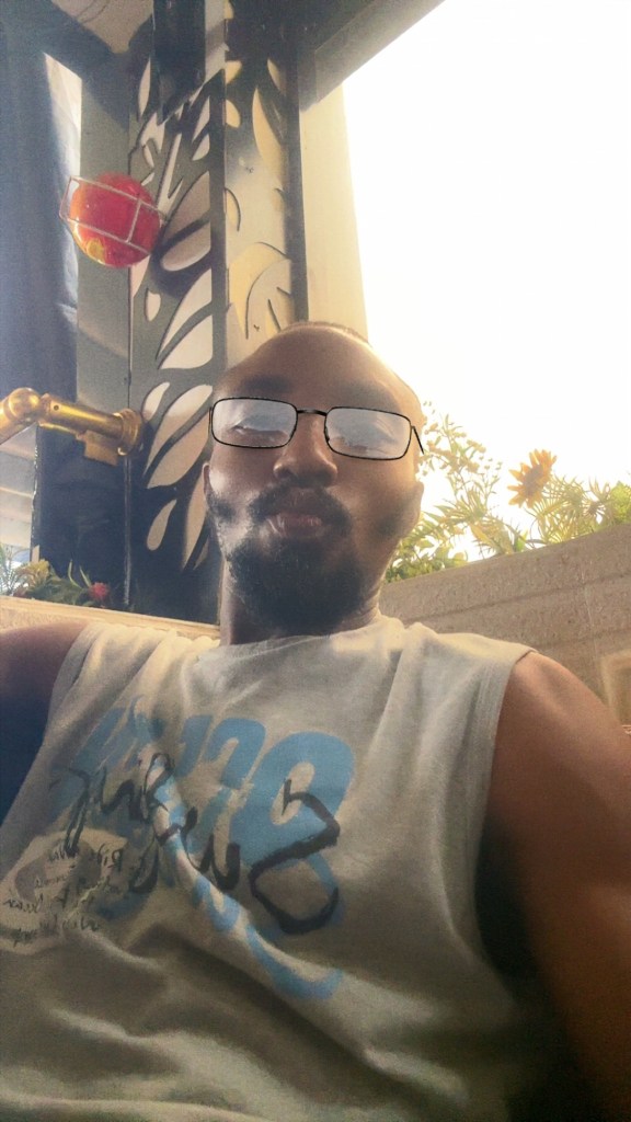 Nnamdi Snr On sunglasses and relaxing 